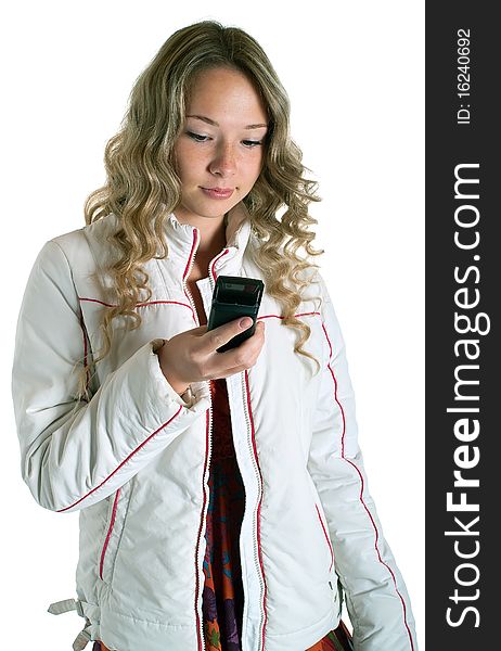 Beautiful girl in white jacket with cellular phone on a white background. Isolation