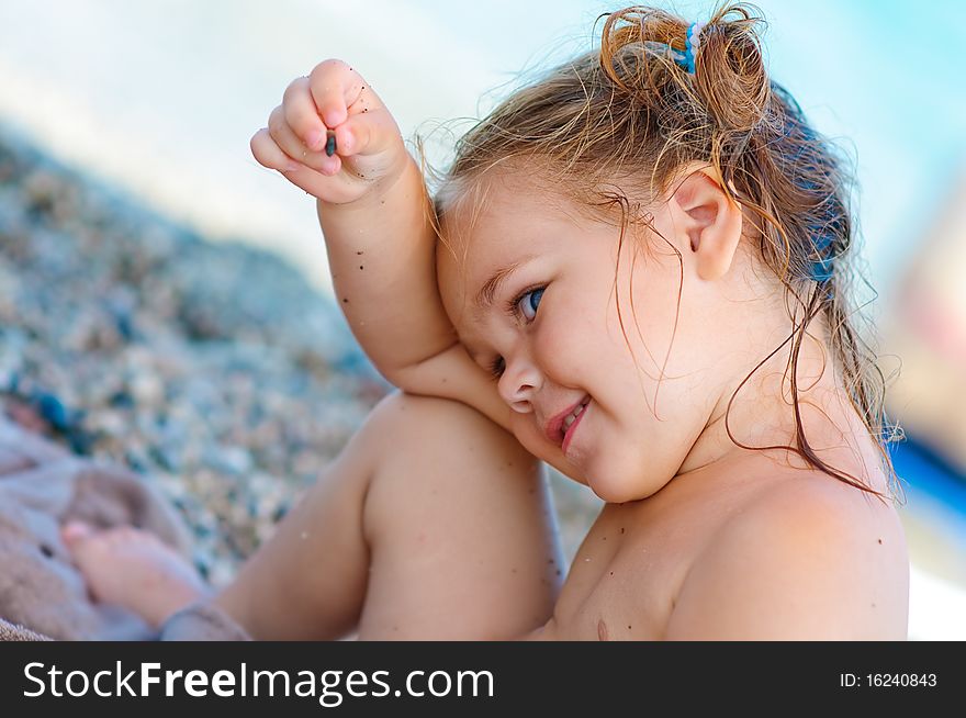 Portrait of smiling cute toddler girl on sea background