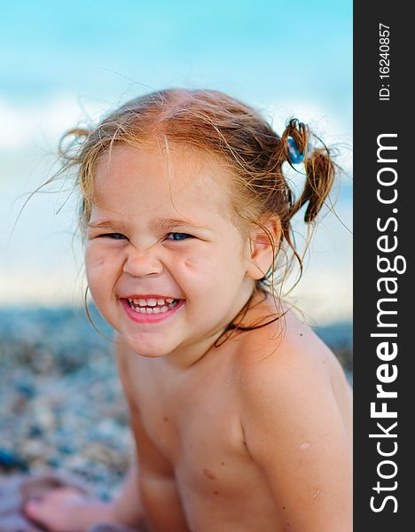 Portrait of smiling cute toddler girl on sea background