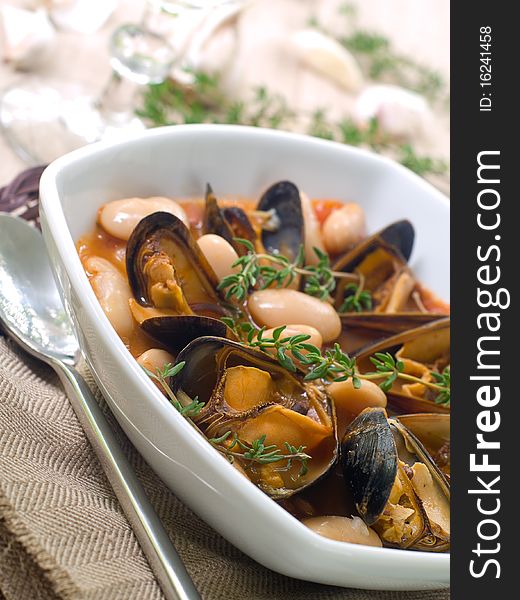 Mussel soup with bean and thyme on bowl