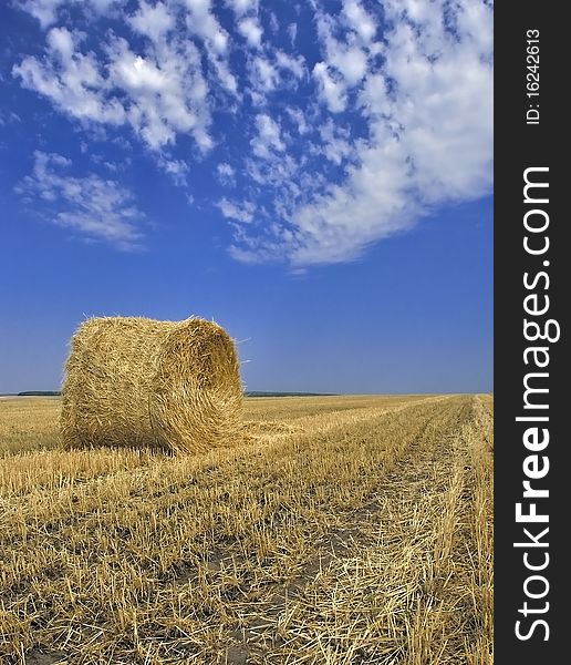 Straw stack in the field against the dark blue sky.