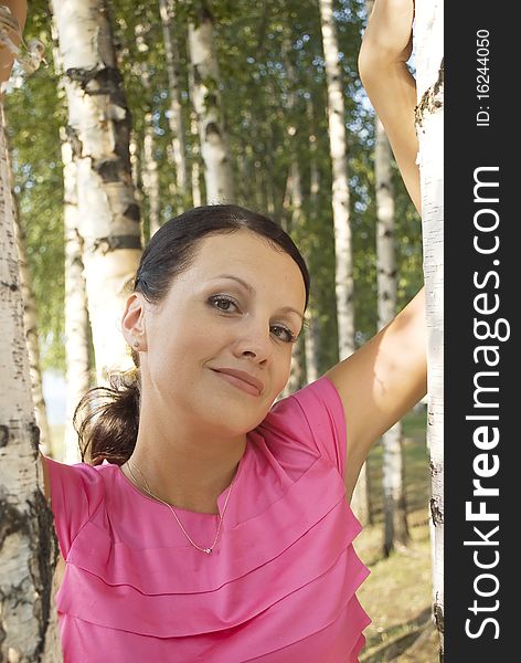 Summer portrait of a very attractive woman near birth tree outside