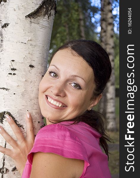 Summer portrait of a very attractive woman near birth tree outside