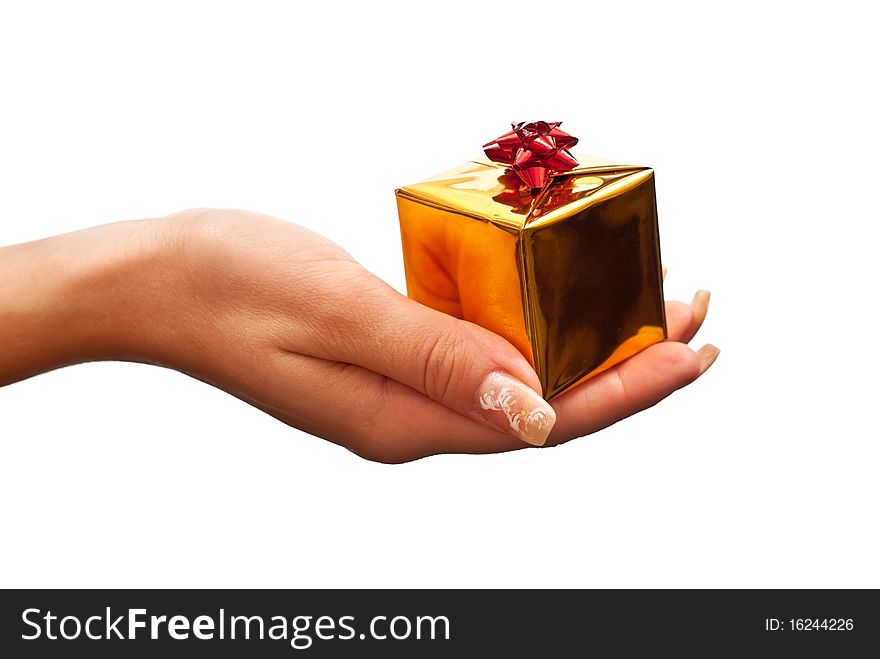 Woman's hand with a small gold gift box with red bow isolated on white background. Woman's hand with a small gold gift box with red bow isolated on white background