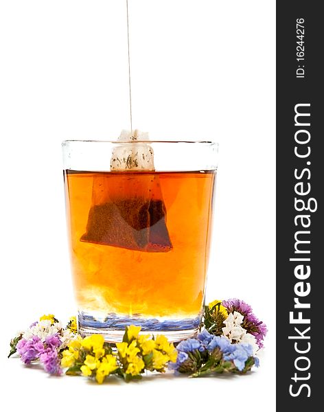 Hot tea in glass cup with flowers. Isolated on white background. Hot tea in glass cup with flowers. Isolated on white background
