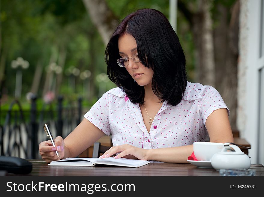 Young beautiful student girl with notepad in the cafe. Young beautiful student girl with notepad in the cafe