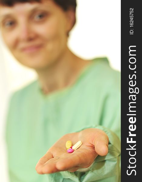 details of a Woman holds pills in a hand