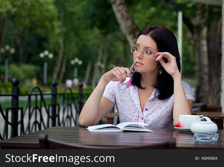 Young beautiful student girl with notepad in the cafe. Young beautiful student girl with notepad in the cafe