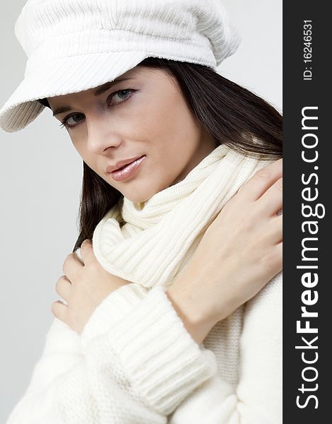 Young woman in soft white sweater and cap. Young woman in soft white sweater and cap