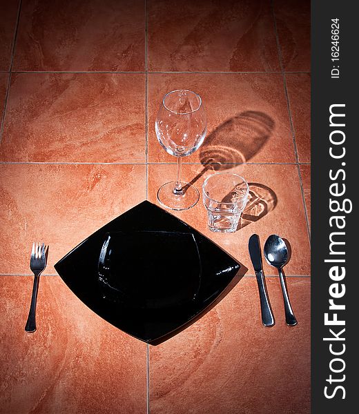 Served tableware on a floor with shadow from glasses. Served tableware on a floor with shadow from glasses