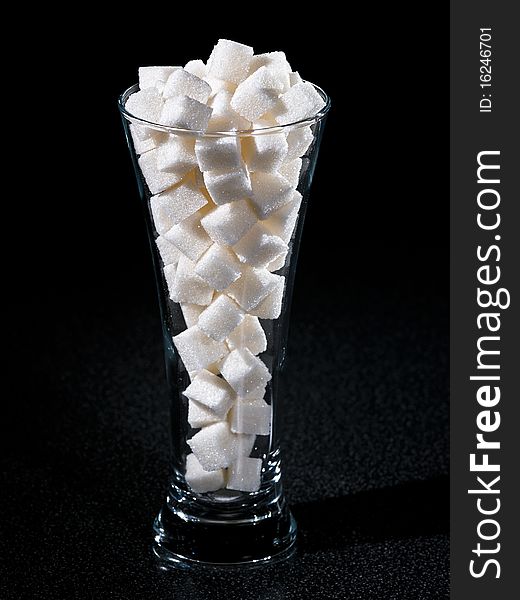 Glass of sugar tubes with dark background. Glass of sugar tubes with dark background