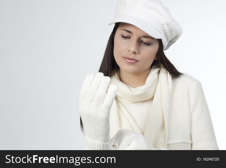 Young woman in soft white sweater and cap, wearing mittens. Young woman in soft white sweater and cap, wearing mittens