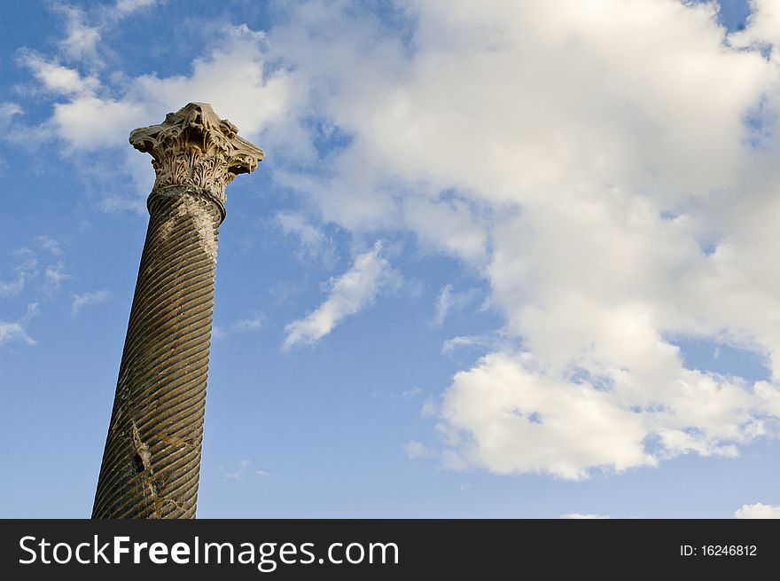 Ancient greek column against a blue sky