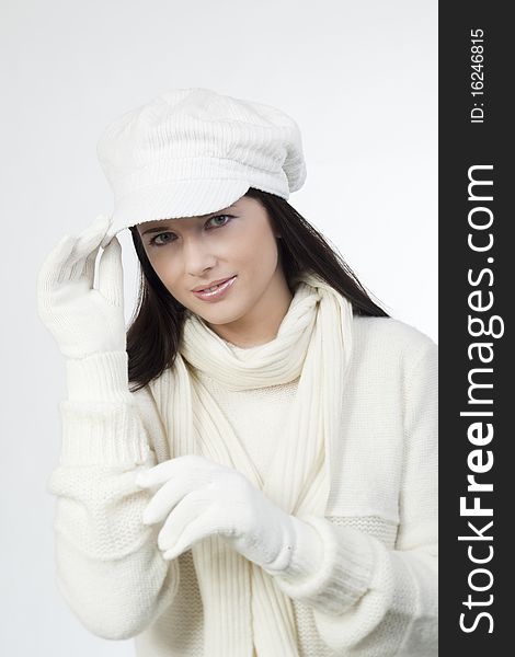 Young woman in soft white sweater and cap, wearing mittens. Young woman in soft white sweater and cap, wearing mittens