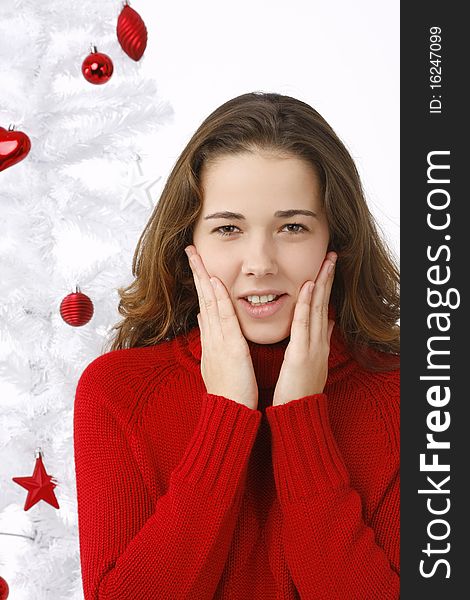 Beautiful young woman next to christmas tree on white background