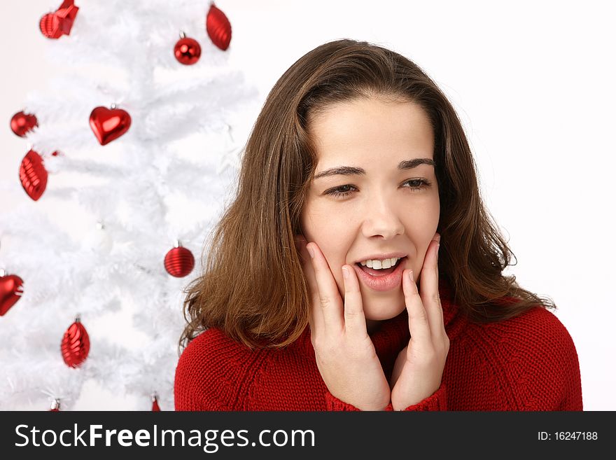 Beautiful young woman next to christmas tree