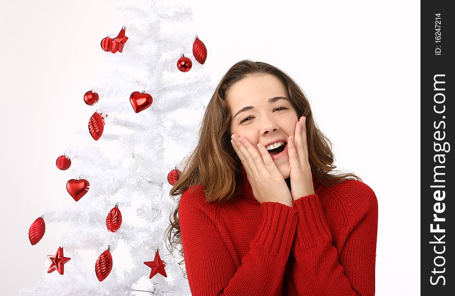 Beautiful young woman next to christmas tree on white background
