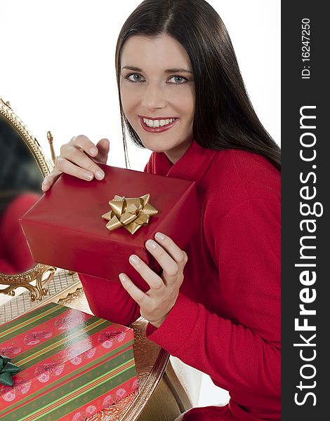 Attractive young woman with Christmas presents against white