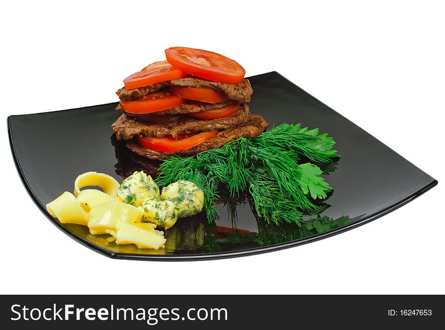 Roast beef on a plate decorated with tomato, isolated on white.