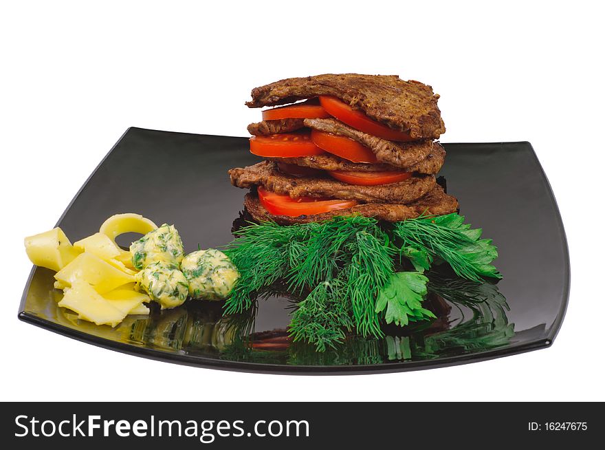 Roast beef on a plate decorated with tomato, isolated on white.