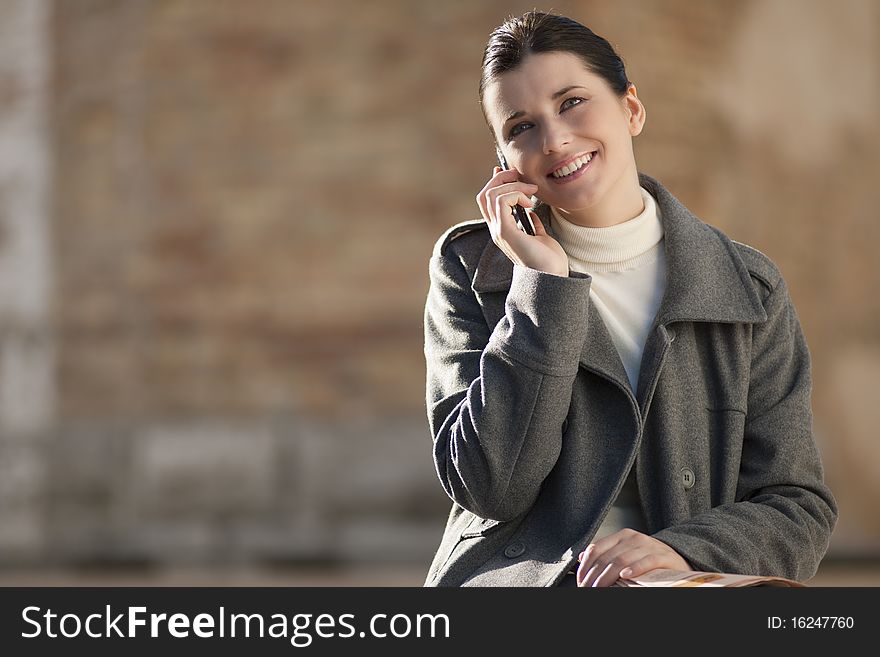 Young woman on mobile phone, outdoors