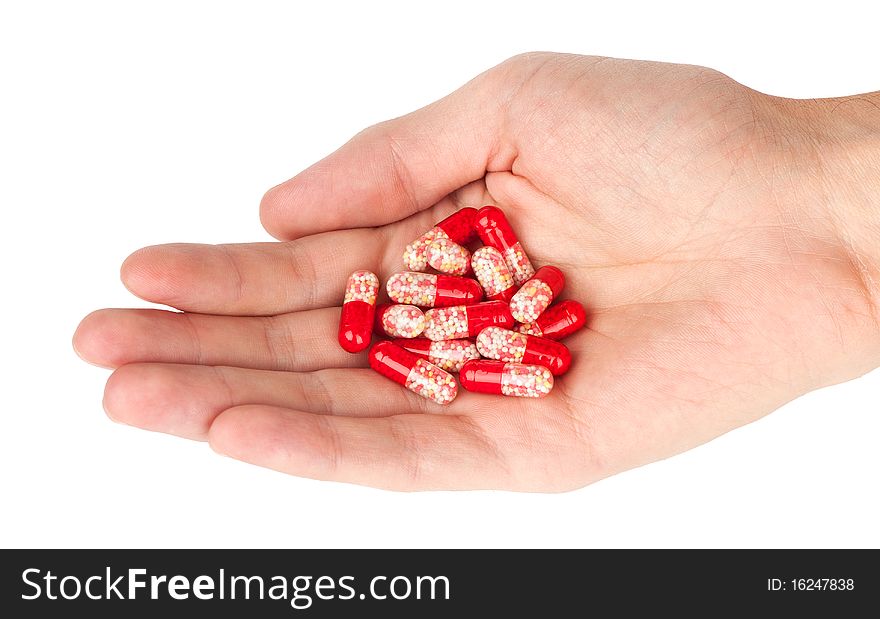 Human hand holding red pills isolated on a white