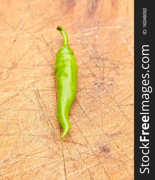 Green chilli pepper on a cutting board