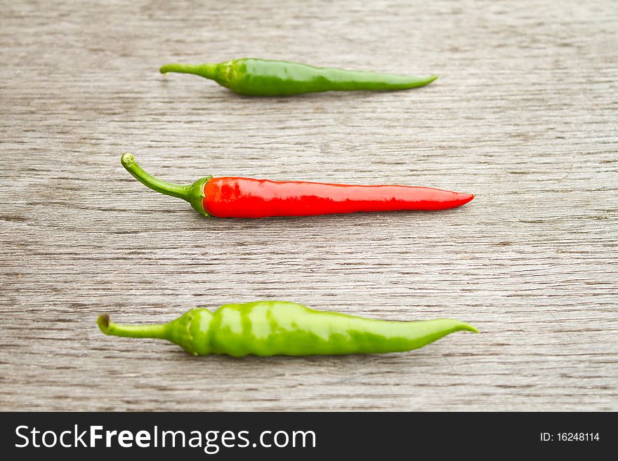 Three chilli hot red and green peppers (focus on red one). Three chilli hot red and green peppers (focus on red one)