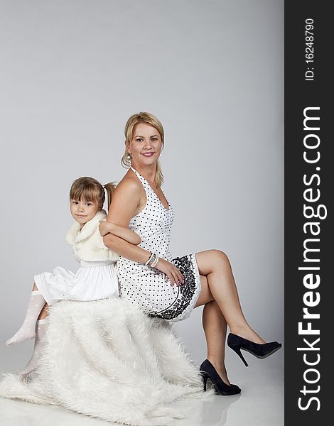 Portrait of two, young beautiful mother and daughter, holding hands, studio image. Portrait of two, young beautiful mother and daughter, holding hands, studio image