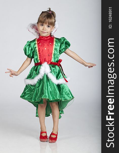 Full length portrait of a cheerful little girl wearing green dress on Saint Patrick's Day, studio image. Full length portrait of a cheerful little girl wearing green dress on Saint Patrick's Day, studio image
