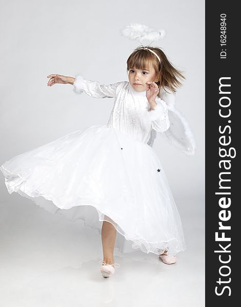 Full length portrait of a lovely little girl dressed as an angel, ready to fly, studio image. Full length portrait of a lovely little girl dressed as an angel, ready to fly, studio image