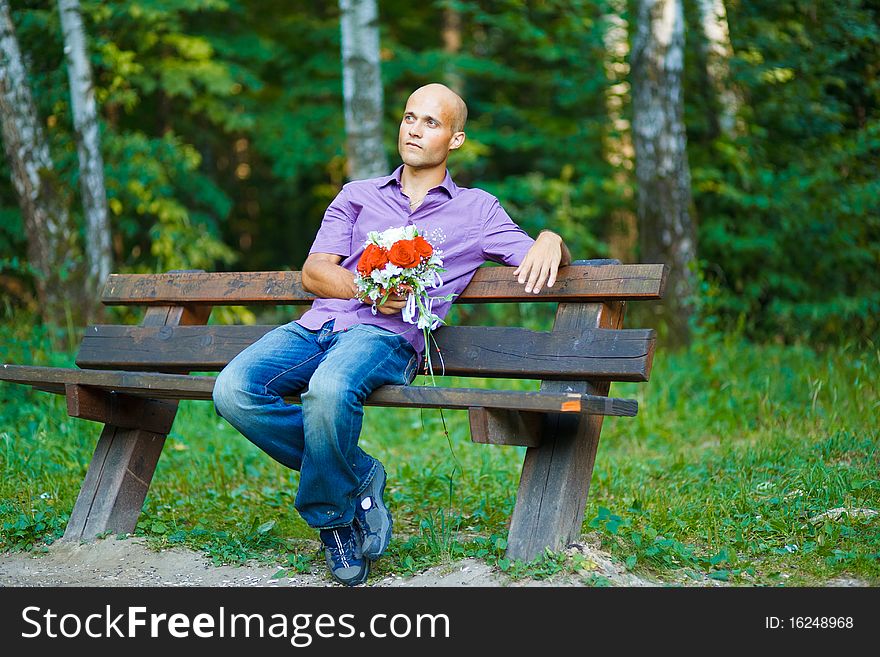 Guy with bouquet waiting for his girlfriend outsid