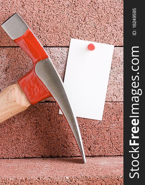 White piece of paper for a message next to a hammer. Add your text to the paper.