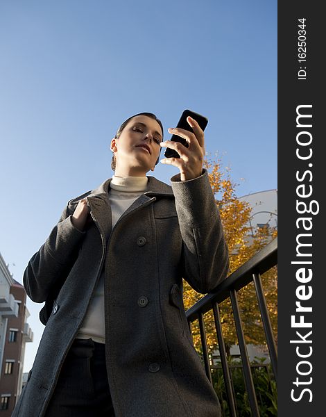 Young woman on the mobile phone, low angle view