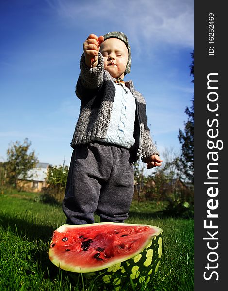 The boy presses a water-melon in hands