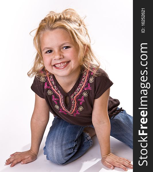 Cute young girl, on her knees smiling for the viewer. Cute young girl, on her knees smiling for the viewer