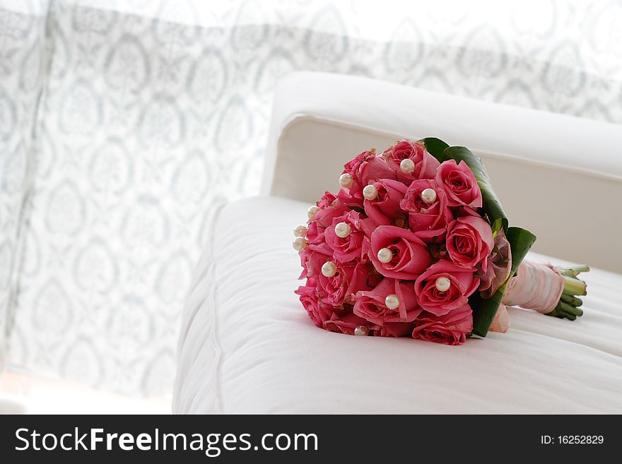 A bouquet of pink roses on a white sofa