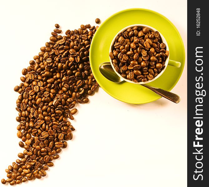 Green cup of coffee with brown beans on white ground