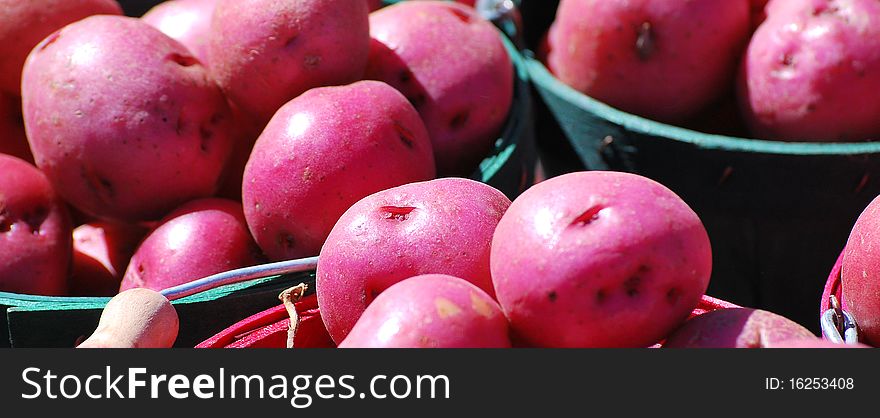 Red potatoes on a produce stand.