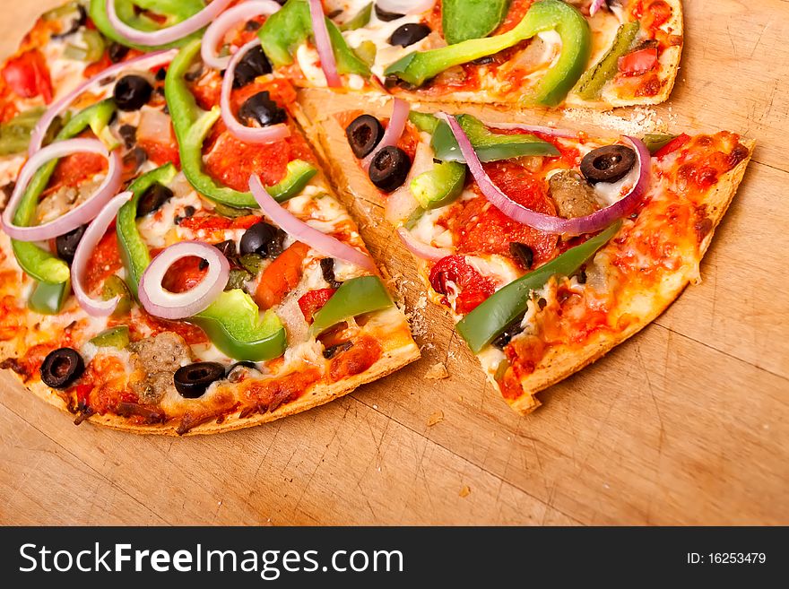 Pizza with pepperoni, bell peppers, black olives and onions. Pizza with pepperoni, bell peppers, black olives and onions