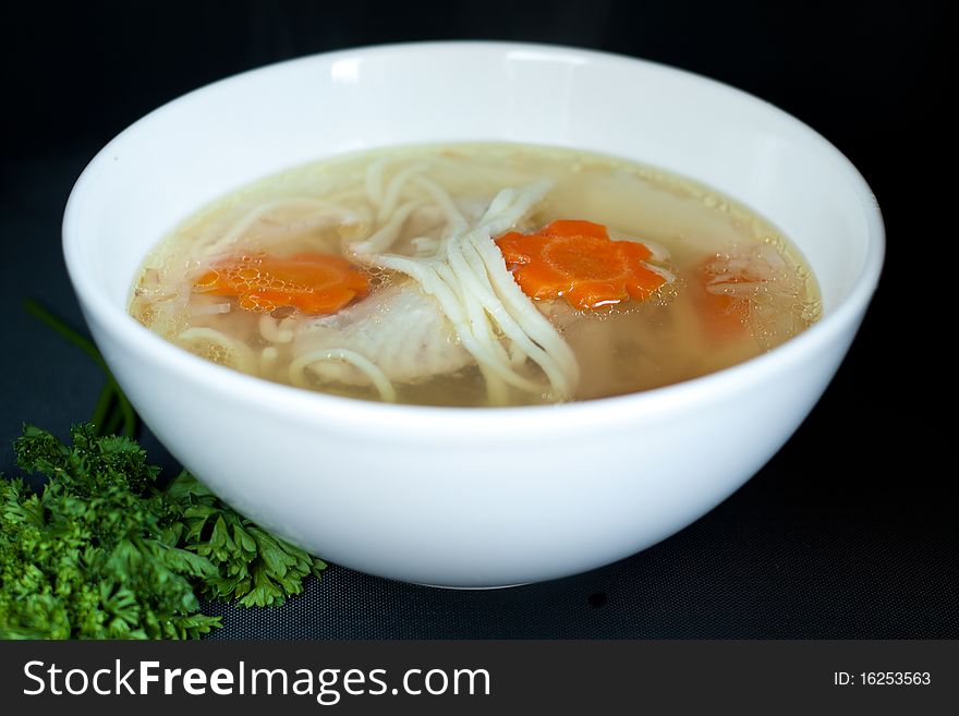 Noodle soup in white plate over the black background. Noodle soup in white plate over the black background