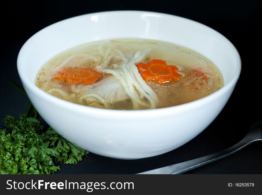 Noodle soup in white plate over the black background. Noodle soup in white plate over the black background