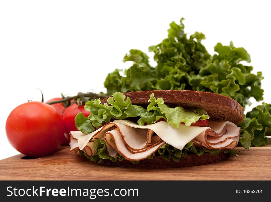 Healthy turkey breast sandwich on rye bread with vine ripe tomatoes and lettuce on white background. Healthy turkey breast sandwich on rye bread with vine ripe tomatoes and lettuce on white background