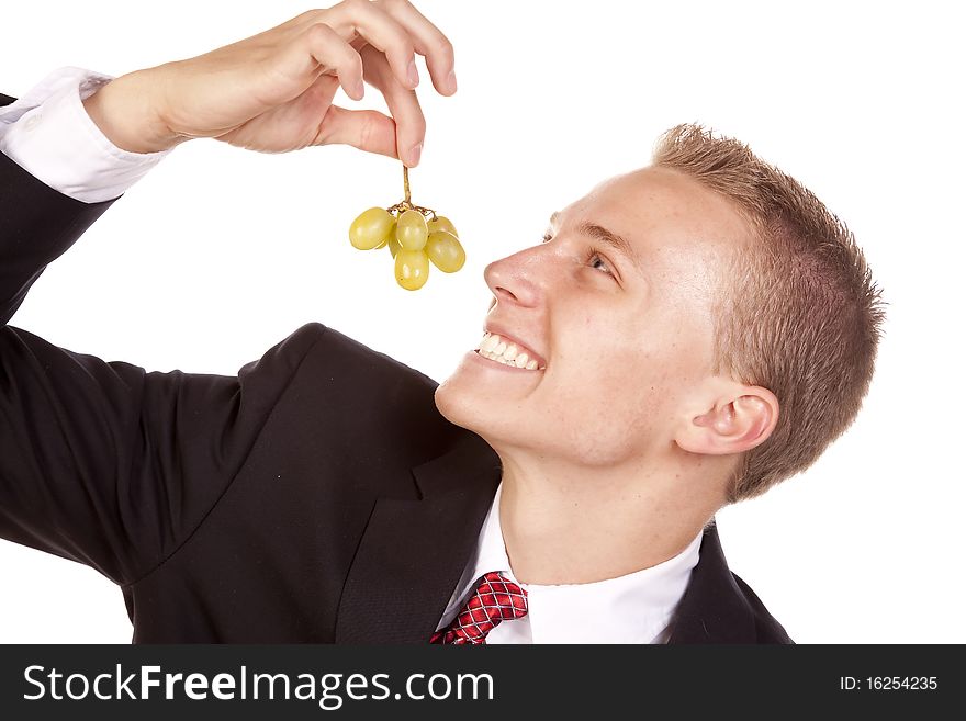 A young man getting ready to eat some green grapes. A young man getting ready to eat some green grapes.