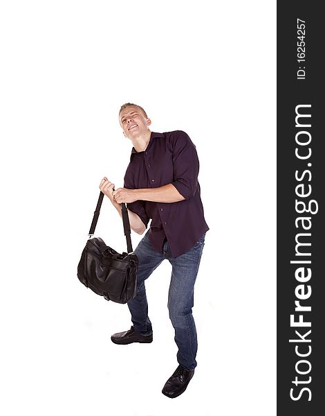 A young man trying to lift his duffel bag off of the ground. A young man trying to lift his duffel bag off of the ground.