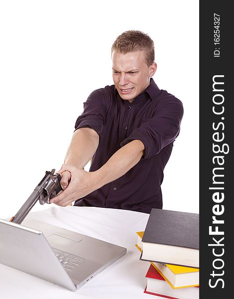 A young man getting ready to shoot his computer because he is so mad. A young man getting ready to shoot his computer because he is so mad.