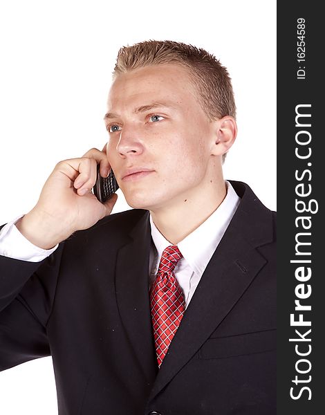 A young business man listening on his phone with a serious expression. A young business man listening on his phone with a serious expression.