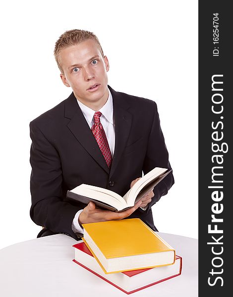 A business man holding a book with an expression of surprise at what he is reading. A business man holding a book with an expression of surprise at what he is reading.