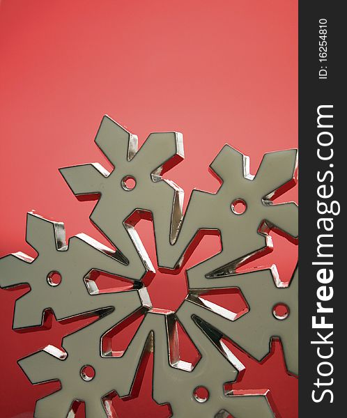White snowflake, metallic on a red backdrop with room for copy and use in holiday materials. White snowflake, metallic on a red backdrop with room for copy and use in holiday materials