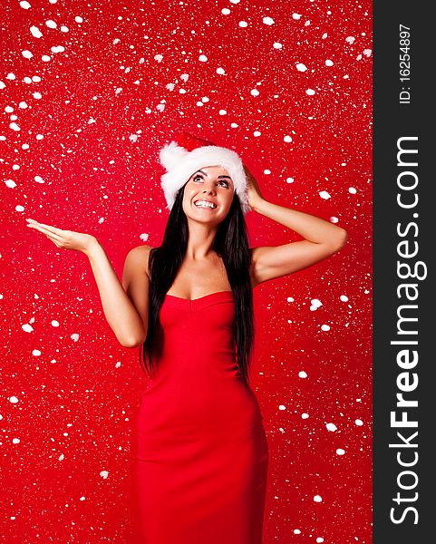 Beautiful happy young woman dressed as santa with snow falling on her. Beautiful happy young woman dressed as santa with snow falling on her